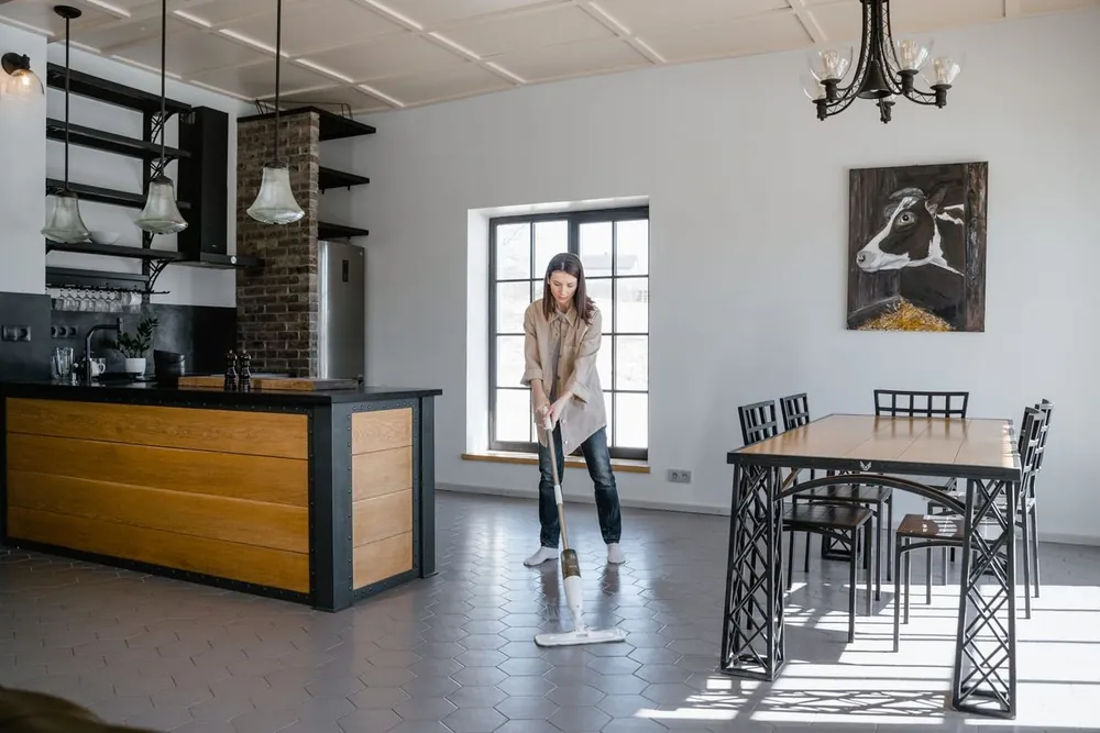 A cleaner mopping the floor of a contemporary apartment